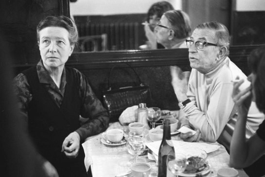 The way it was: French intellectuals Simone de Beauvoir and Jean-Paul Sartre at a cafe in Paris with a bottle of wine on the table. (May 27, 1970)